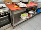 une cuisine équipée d'une cuisinière, d'un four, d'un évier et d'autres éléments posés sur le plan de travail