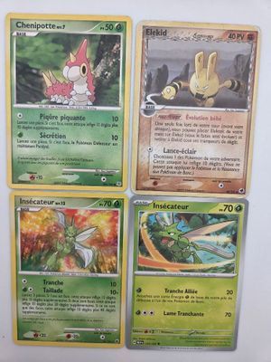 Quatre cartes Pokémon sont posées sur une surface blanche, et l'une d'entre elles représente un dragon.