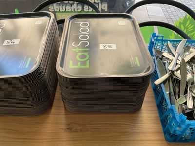 a lot of forks and spoons in a container on a table