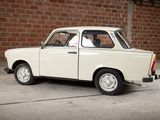 a small white car that is parked in front of a brick wall