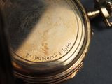 a close up of a pocket watch on a table