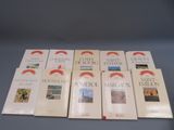 six livres posés sur une table, sur fond bleu et ornés d'un ruban rouge