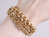 gold plated chain bracelet with pyramids on a woman ' s wrist