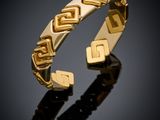 a close up of a gold bracelet on a black surface