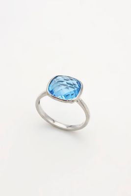 Gros plan sur une bague ornée d'une topaze bleue