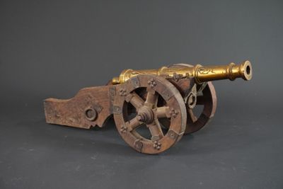 Canon en bronze doré sur monture bois et armature métal.