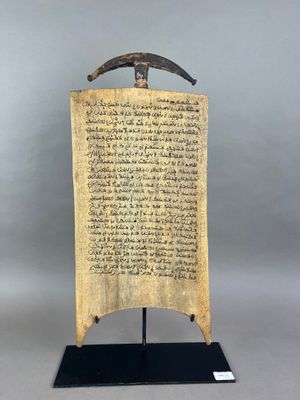 une plaque en bois portant une inscription, posée sur un socle