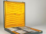 an open suitcase with silverware in it on a white surface