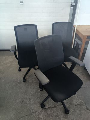 trois chaises de bureau noires placées les unes à côté des autres dans une pièce