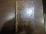 un vieux livre posé sur une table en bois à côté d'une paire de chaussures