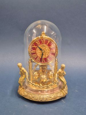 a clock inside of a glass dome on a table
