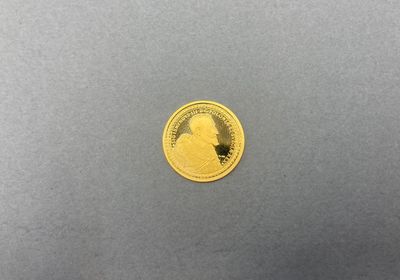 gros plan d'une pièce d'or sur une surface grise