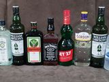 de nombreuses bouteilles d'alcool de toutes sortes alignées sur une chaise