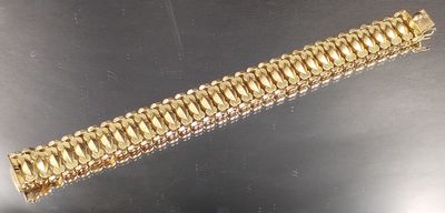 gros plan d'un bracelet en or sur une table