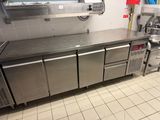 une cuisine avec des plans de travail et des placards en inox