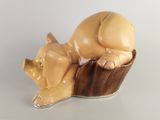 a figurine of a pig laying on a cupcake