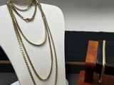 deux colliers et un bracelet posés sur un présentoir posé sur une table