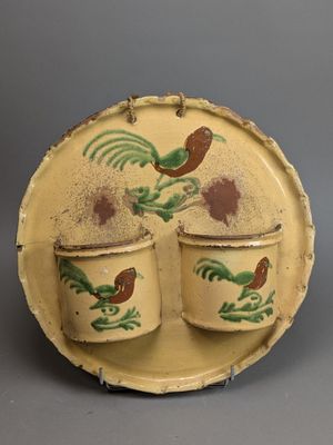 two cups and a saucer on a plate with a rooster design