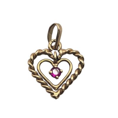 a gold heart shaped pendant with a pink stone in the center