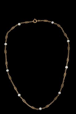 un collier en or avec des perles et une chaîne