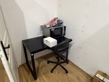 un petit bureau sur lequel se trouve une imprimante, dans une petite pièce