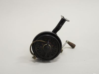 an old fishing reel on a white surface