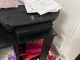 a printer sitting on top of a desk next to a chair