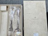 two spoons and a fork in a box on a table