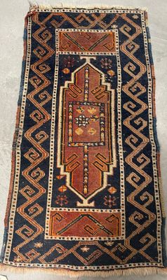 an old rug is laying on the floor next to a wall