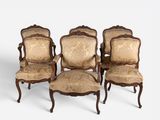 four antique chairs with upholstered arms and a gold upholstered back