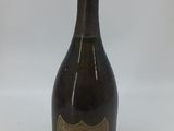 une vieille bouteille de champagne posée sur une table blanche