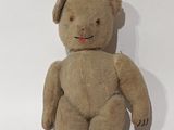un ours en peluche marron assis sur une surface blanche