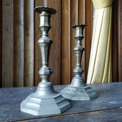deux bougies posées sur une table devant un rideau