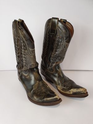 une paire de bottes de cow-boy marron posées sur une surface blanche