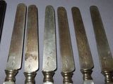 six knives are lined up in a row on a table