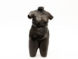 black sculpture of a woman with a large breast on a white background