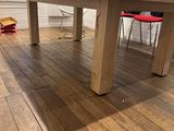 a wooden table in the middle of a hardwood floor