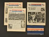 three old newspapers are on display on a black surface