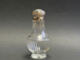 a small glass bottle with a silver lid on a table