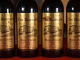 three bottles of red wine are lined up on a table