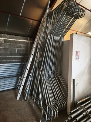 a pile of metal pipes in a room with a wall