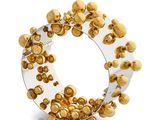 a close up of a ring with gold balls on a white background