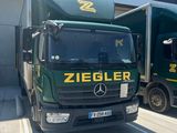 two trucks that are parked next to each other in front of a building