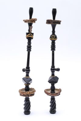 une paire de bougeoirs noirs et dorés sur des socles en marbre
