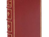 un livre rouge avec des bordures dorées et orné de bordures dorées