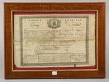 an old certificate is displayed in a wooden frame