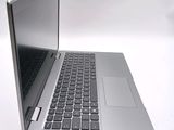 a silver laptop with a black keyboard on a white surface