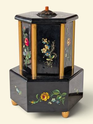 une petite boîte noire décorée de fleurs peintes