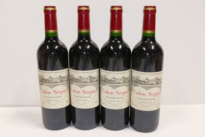 trois bouteilles de vin rouge sont alignées sur une surface blanche