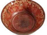 bowl is red and brown with designs on the outside of the bowl